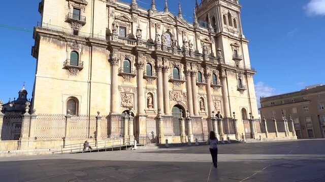 Woman walking along the esplanade of the huge cathedral of Jaen in Andalusia.