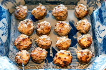 Bite-sized mushrooms stuffed with cream cheese and bacon served on a Japanese Imari blue and white porcelain plate