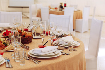 The catering table set service with silverware and glass stemware at a restaurant before the party. Selective focus on the champagne glasses