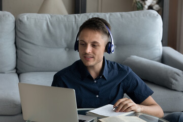 Positive student guy, intern in wireless headphones taking online business course, making video...