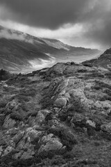 Black and white Epic Autumn landscape image of view along Nant Fracon valley in Snowdonia National Park with dramatic evening sky and copy space