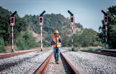 Naklejka premium Engineer under inspection and checking construction process railway switch and checking work on railroad station .Engineer wearing safety uniform and safety helmet in work.
