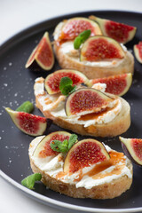 Healthy sandwiches with fresh figs and cream cheese, mint leaves