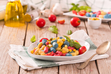 Colored gnocchi with vegetables and sweet corn.