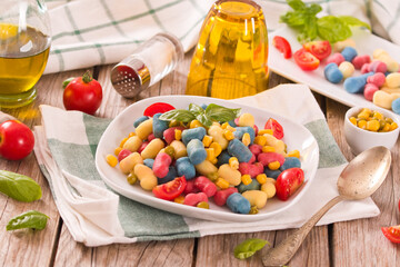 Colored gnocchi with vegetables and sweet corn.