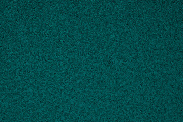 Deep turquoise winter background. Dark aquamarine tinted wallpaper. Ice crystals surface on window glass close-up. A pattern of chaotic spots. Abstract cyan backdrop