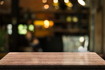 Empty wooden table top with lights bokeh on blur restaurant background.