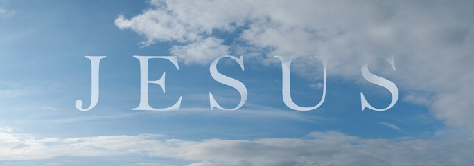 Abstract religious concept. Name of Jesus written on the blue sky with some clouds and sunlight.