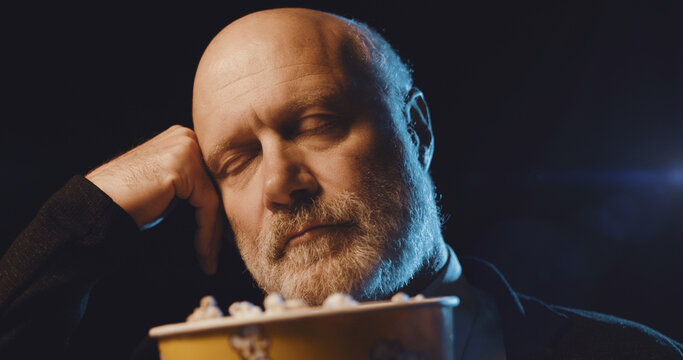 Man watching a boring movie at the cinema
