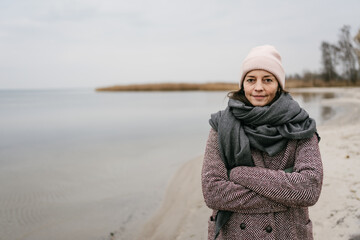Woman posing on a sandy beach on a cold winter day