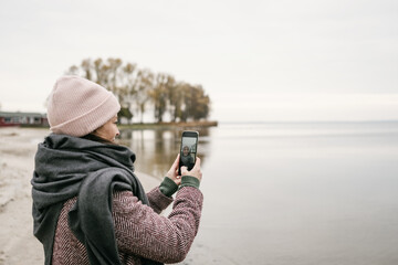 Smiling woman or female tourist taking a selfie in winter