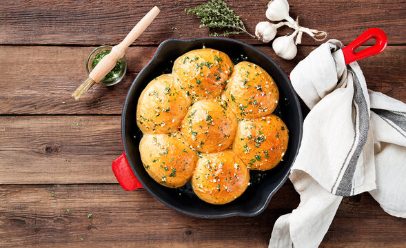 Fresh baked Homemade Garlic Butter Buns. Wooden background. top view
