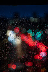 rainy days.rain drops on the window and traffic bokeh in distance