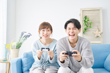 テレビゲームする男女　リビング