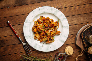Portion of gourmet fried mushrooms with onion garnish