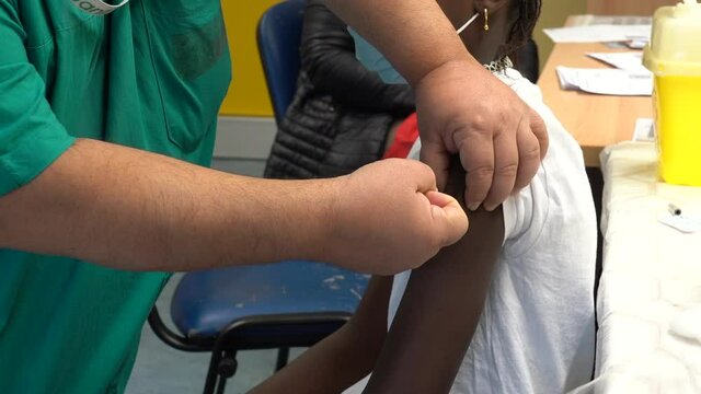 Europe, Italy,  December 2021 - Vaccination against covid-19 Coronavirus epidemic with Pfizer vaccine hospital - black woman child  Omicron variant vaccine - African patient, vaccine on pediatric age 