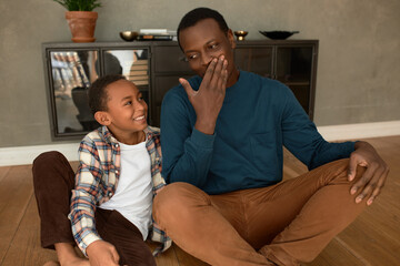 Warm confident relationships of dad and his kid spending time together at home on weekend after...