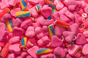 Assorted tasty gummy candies. Pink jelly sweets background.