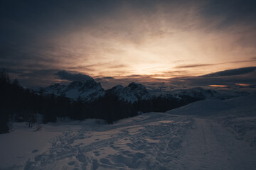 Sunset panorama of the majestic north east face of Mount Civetta in winter conditions seen by a road bated in the snow. Fiorentina Valley, Dolomites, Italy