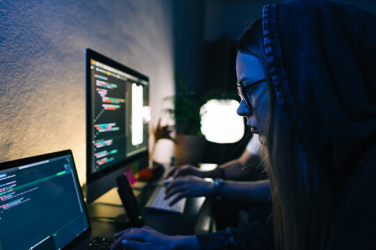 Mobile developers team writes program code on a computer, programmers work in home office.