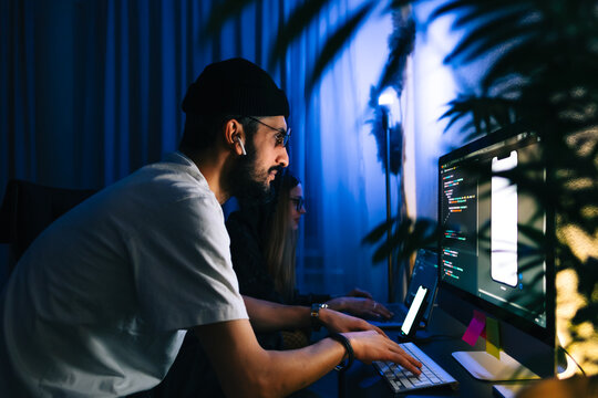 Mobile developers team writes program code on a computer, programmers work in home office.