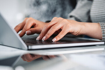 Woman hands typing on the laptop keyboard in office room