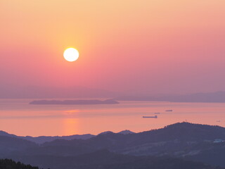 高原から、海と夕日を見る