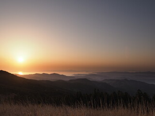 高原から、海と夕日を見る