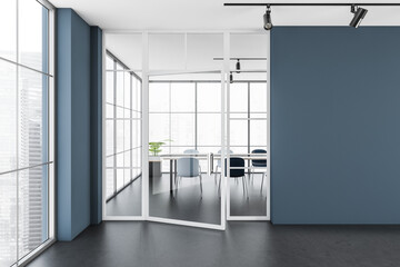 Dark office room interior with empty blue wall, desk, armchairs