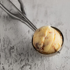 Vanilla with chocolate ice cream into the ice cream scoop on white background