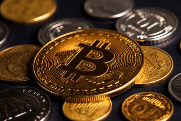 Close up of metal shiny bitcoin crypto currency coin with Ukrainian hryvnia coins. Electronic decentralized money concept. legalise Bitcoin and cryptocurrencies in Ukraine