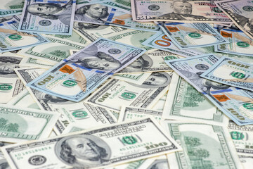 One hundred dollars pile as background.