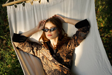 pretty woman lies in a hammock wearing sunglasses summer lifestyle leisure