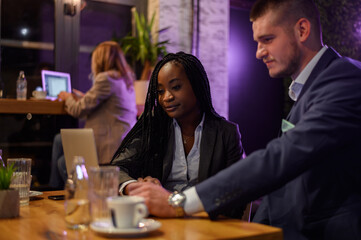 Two business people having a meeting in a cafe while using a laptop