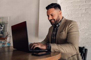 Businessman working on his laptop while drinking coffee in a cafe