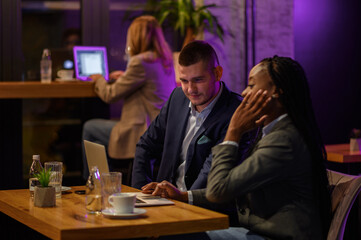 Two business people having a meeting in a cafe while using a laptop