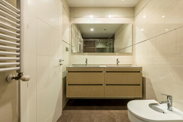 Modern bathroom in cream and brown tones with two taps and two sinks in a vacation rental apartment