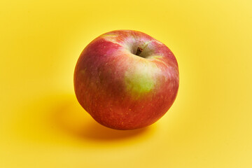  Single red apple fruit over yellow background