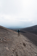 Escursionisti scendono tra le rocce del Vulcano Etna