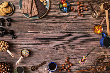 Still life of chocolates, roasted salted hazelnuts and almonds, orange juice, wooden plank table...