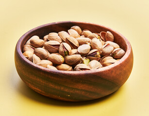  Bowl of pistachios over yellow background