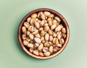  Bowl of pistachios over green background