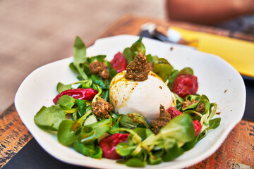 Beautiful burrata cheese with pesto on lambs lettuce salad image