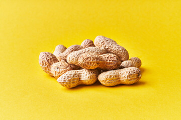  Bunch of peanuts with shell on a yellow background