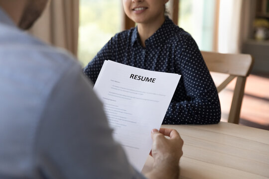 Employer reading paper resume on job interview, listening to candidate presenting professional work experience. HR recruiter and vacancy applicant discussing employment terms, hiring, staffing