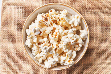  Bowl of salty popcorns on a cloth surface