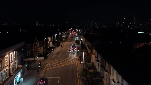Driver signalling by headlights, giving way to other car, night city