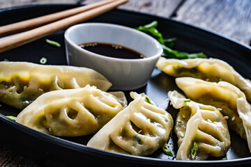 Gyoza - delicious dumplings filled with vegetables  and minced meat, wrapped into thin dough served...