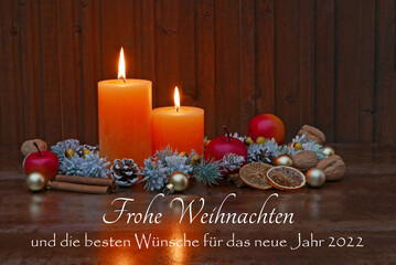 Fototapeta na wymiar Weihnachtskarte: Arrangement mit Kerzen,Zweigen und dem Text frohe Weihnachten und die besten Wünsche für das neue Jahr 2022.