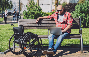 Freelancer with a physical disability in a wheelchair working at the park